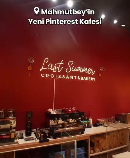 The red wall and neon sign of Last Summer Croissant & Bakery, with a location line naming the neighbourhood at the top