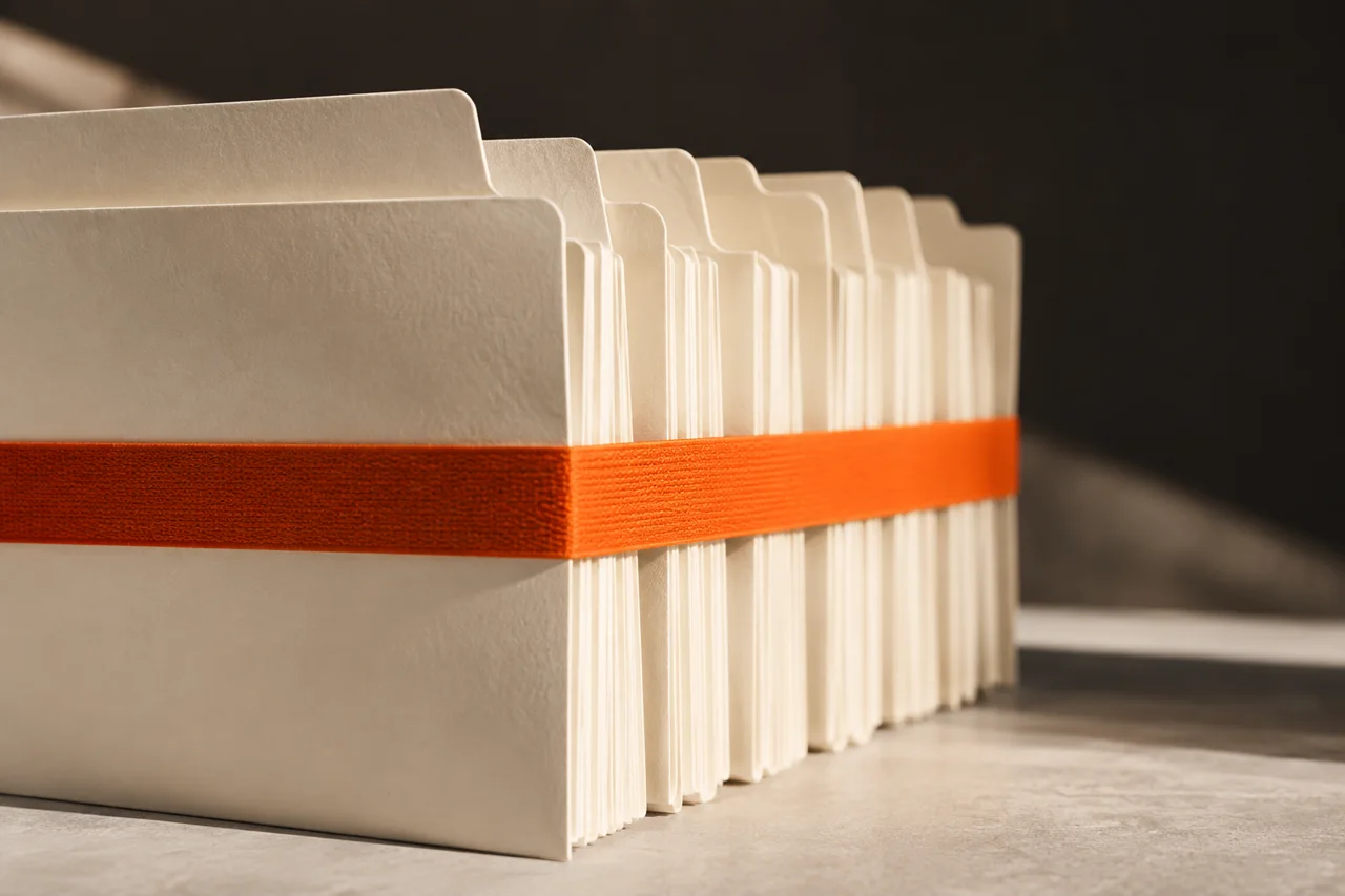 White file folders held together by an orange band